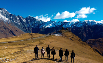 Group of people walking towards a mountainous landscape