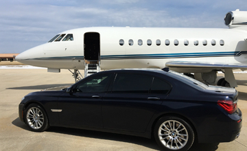 Black car and private charter jet in background